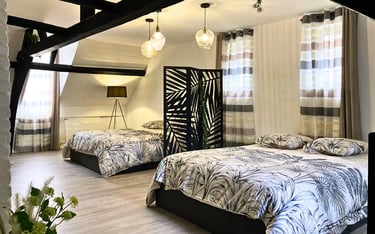 Grande chambre avec lits doubles, idéale pour hébergement de groupes professionnels.