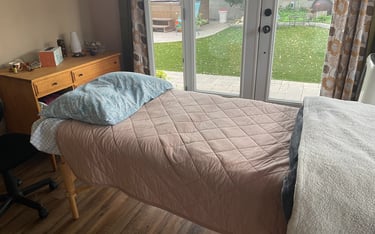 Massage table with pink blanket in a treatment room