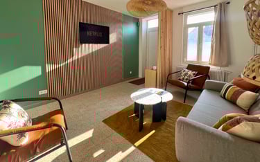 Salon moderne avec TV Netflix et canapés confortables dans logement meublé pour pros.