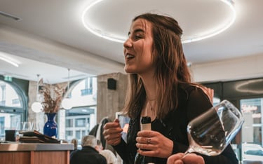 a woman is holding a wine glass in a restaurant