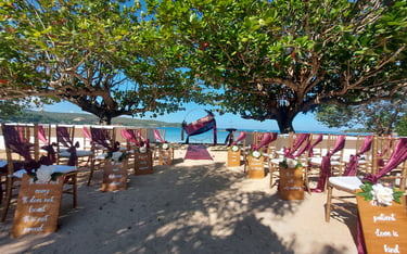 a beach wedding ceremony with aisle marker and chairs
