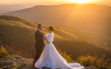 a bride and groom standing on a mountain top