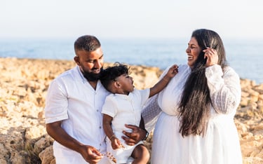 a family of three people standing on rocks