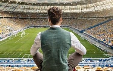 uomo seduto sopra tante monete dentro campo da calcio