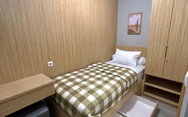 Kamar kos premium di Kos Si Bos Surabaya Barat dengan tempat tidur single, meja belajar,  dan lemari