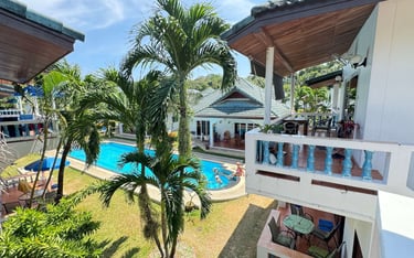 Tropical garden and swimming pool view from Yanui Apartments terrace