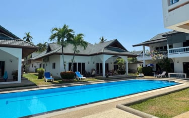 Yanui Apartments Phuket exterior with large private swimming pool and garden