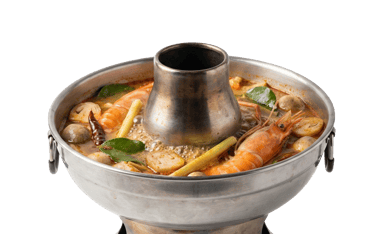 a traditional Thai hotpot set with a central soup pot, fresh shrimp, vegetables