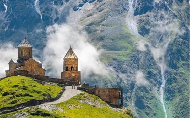 Gergeti Trinity Church in Kazbegi, Georgia, nestled against the misty Caucasus Mountains.