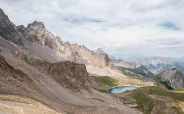 a person standing on a mountain top with a lake in the background