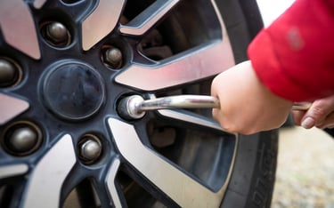 a person tightening a wheel nut of a tire