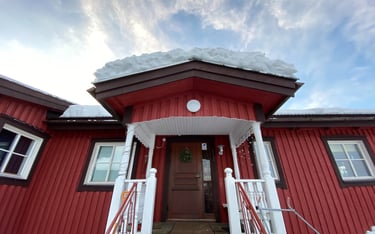 a red house with a red door and white stairs