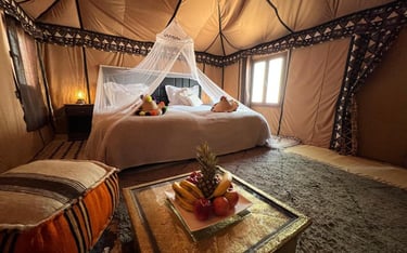 a bed with a canopy tented bed and a table with fruit on it