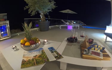 Villa Fay outdoor lounge at night with a glass of wine