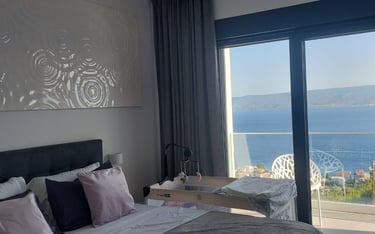 Villa Fay bedroom with a large bed and a view of the ocean