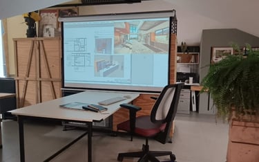 ala com mesa de trabalho e projeção de projeto arquitetônico no estúdio Arqmaisart