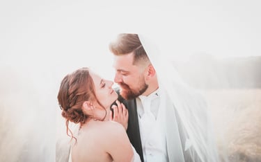 a bride and groom standing in a field
