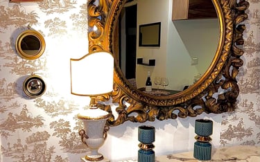Vintage gold-framed mirror and table lamp in stylish Sicilian villa interior
