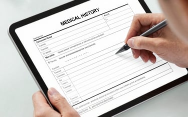 A patient using a stylus to fill out a digital medical history form on a tablet.