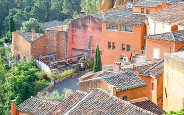 Aerial view of terracotta ochre houses and tiled roofs in Roussillon, a scenic village in Provence, France.