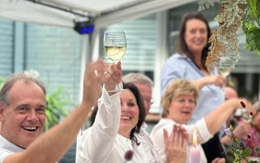 Mensen proosten tijdens een luxe verjaardagsdiner aan huis, verzorgd door Xagis Catering.