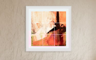 Abstract photographic collage artwork in warm orange and red tones displayed in a white frame on a textured wall
