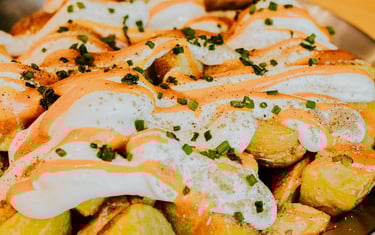 Ración de patatas bravas caseras con salsa brava y alioli del restaurante Santa Lola