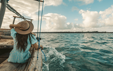 Una mujer en un velero navega mirando el horizonte