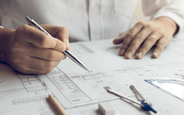 a man is sitting at a table with a pen and pencil