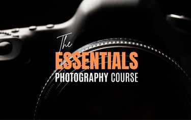 Close-up of a camera lens with text “The Essentials Photography Course” overlayed.
