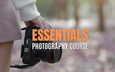 Close-up of a person holding a DSLR camera with text overlay reading Essentials Photography Course.