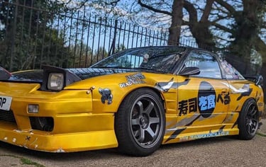 a yellow car with a large number of stickers on it