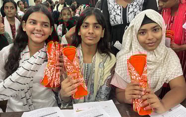3 Schoolgirls holding up a Hanaru reusable sanitary napkin