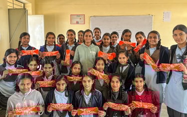 Class of schoolgirls holding up a Hanaru reusable sanitary napkin