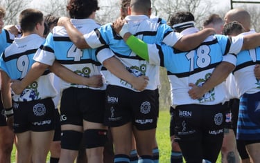 a group of people standing in a circle with rugby shorts