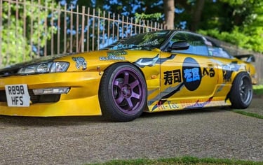 a yellow car with a large number of stickers on it