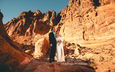 a man and woman standing on a rocky cliff