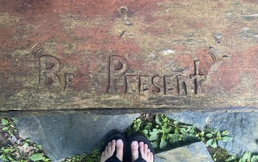 words "Be present" carved into wood