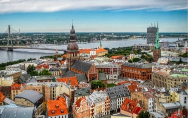 Panoramic aerial view of Riga Old Town skyline featuring the Daugava River and historic church spires in Latvia.