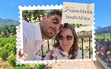 A happy couple wearing sunglasses at a Franschhoek South Africa vineyard on a sunny day.