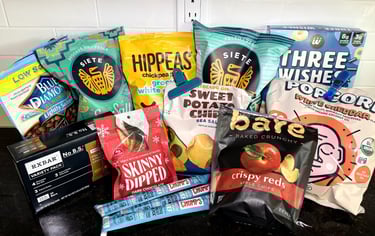 Healthy low sugar snack favorites with chips, popcorn, nuts, protein bars, and apple chips