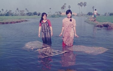 Kayoko and another woman washing fabric in a river to remove excess dye.