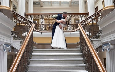 Groom is holding bride dipping her and kissing 