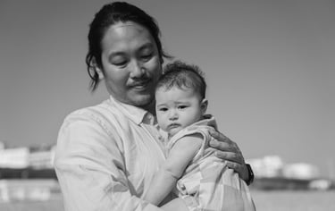 Black and white photo of father holding his baby in the arms