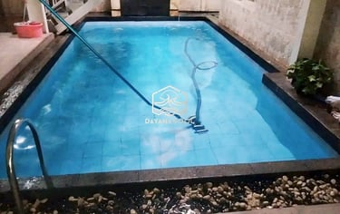 Teknisi membersihkan kolam renang menggunakan alat khusus
