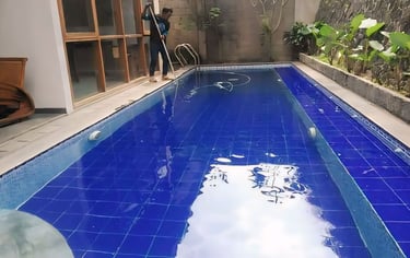 kolam renang sederhana di halaman belakang rumah dengan keramik berwarna biru tua