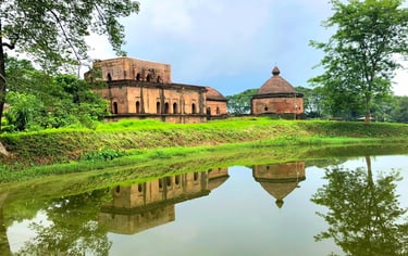 The historic Talatal Ghar and Ahom architecture reflected in a serene pond at Sivasagar, Assam.