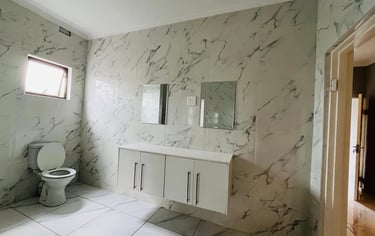 a bathroom with a toilet and a toilet paper roll, House Construction Frans-del Investment CC Constru