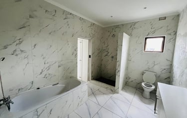 a bathroom with a tub tub and a toilet, House Construction Frans-del Investment CC Construction comp
