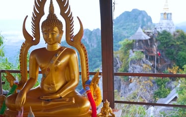 Temple statue in Lampang, Thailand, with background view of mountains.